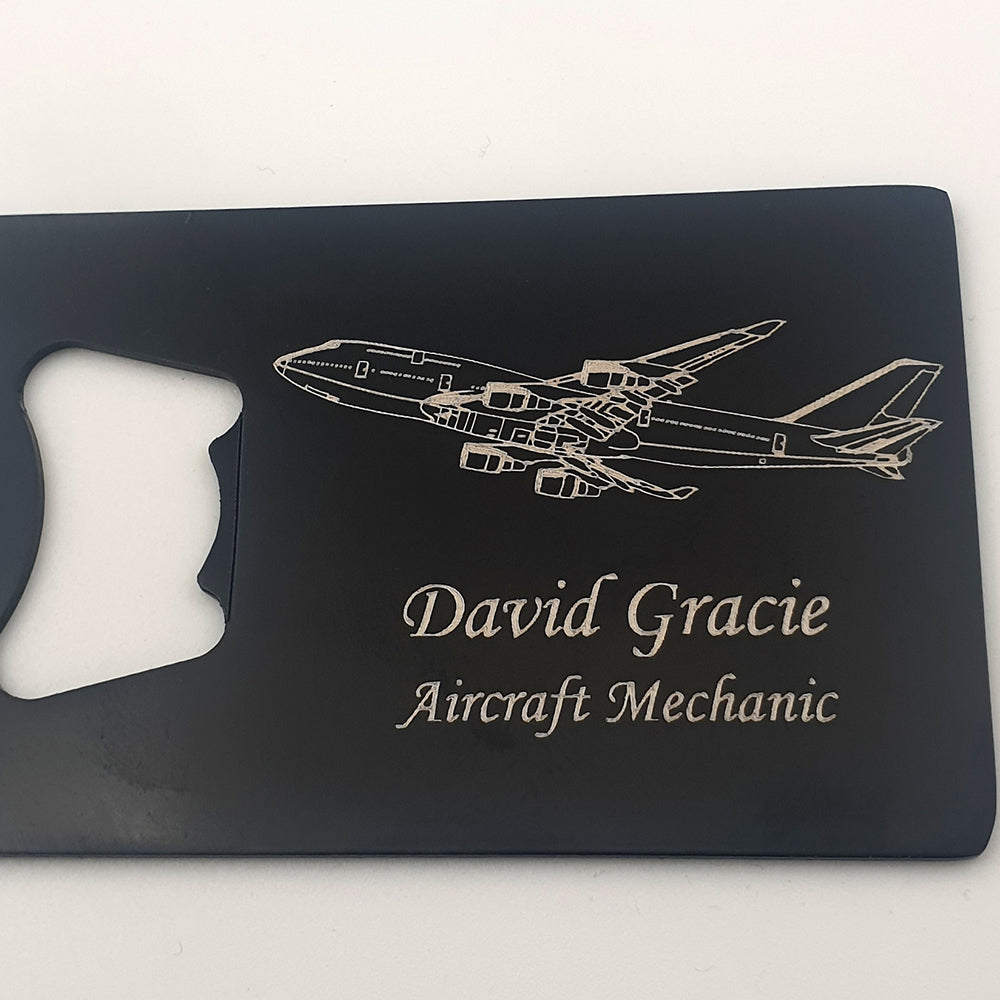 Boeing 747 engraved on black bottle opener with engraved name in Monotype Corsiva font.