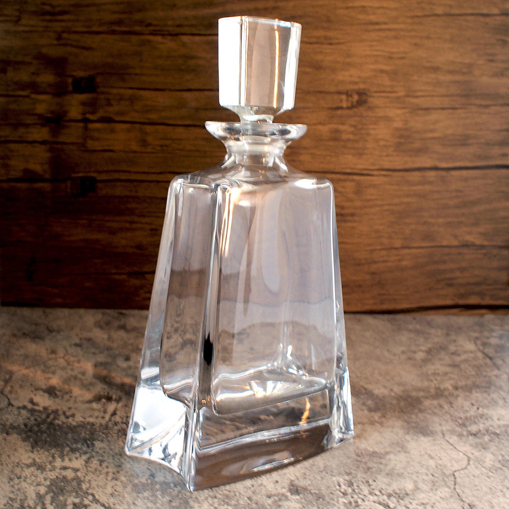 angled image of a tall boston spirits decanter showing its side curve with stopper in place