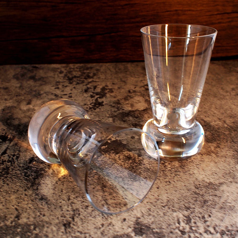 pair of fire slammer glasses, one on its side and one stood proud near by.