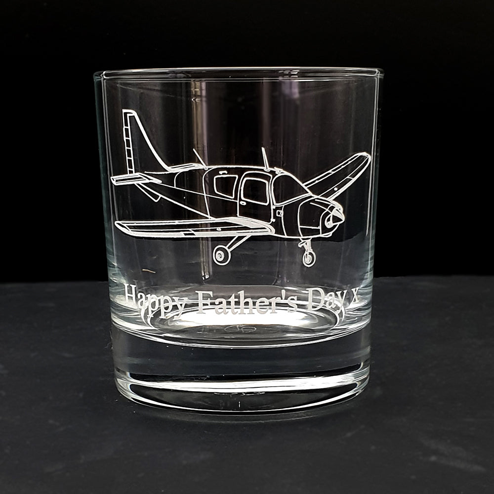 Clear glass tumbler with Beagle pup airplane engraving and 'Happy Father's Day' text on a black background