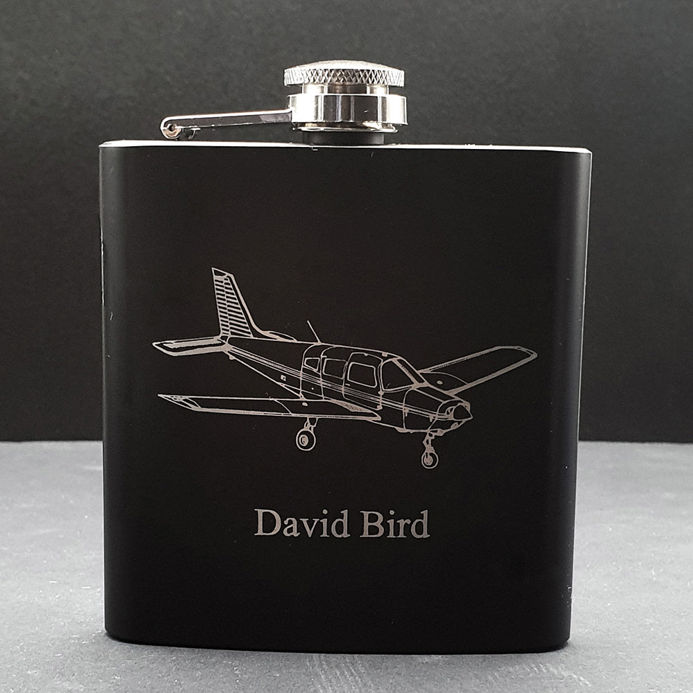 Black hip flask with Piper PA28 Aircraft engraving and 'David Bird' text on a dark background