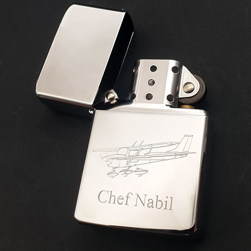 Silver lighter with engraved Cessna 152 airplane and 'Chef Nabil' text on a black background