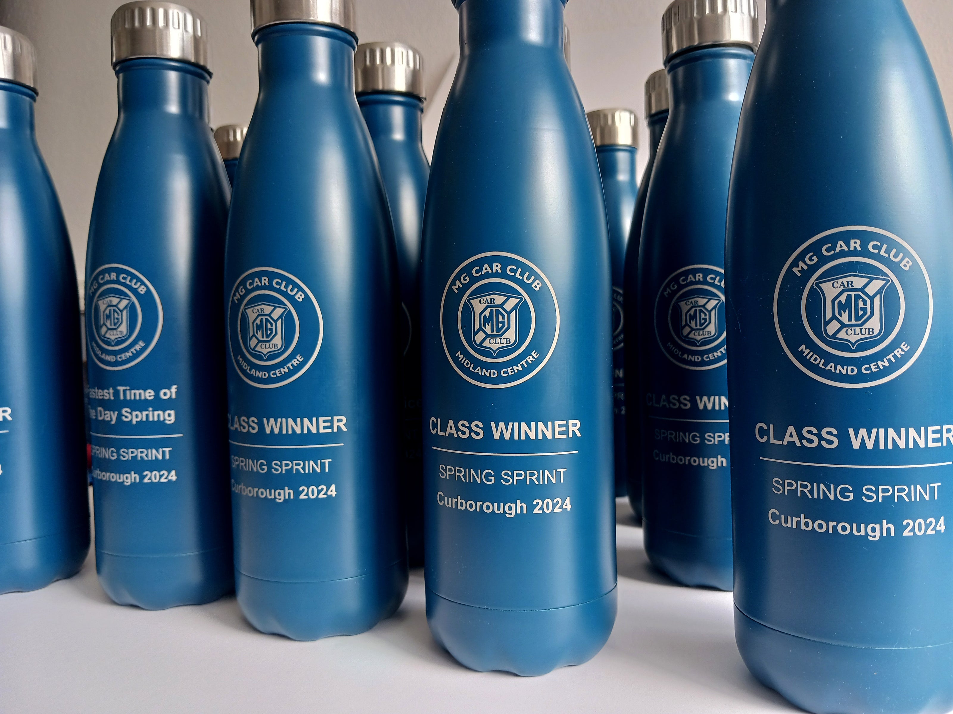 Collection of a blue thermal bottles engraved for the MG car club events