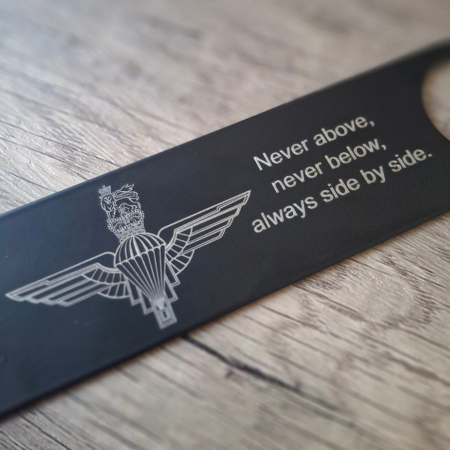 parachute airborne badge with engraved text on a a bartenders bottle opener.