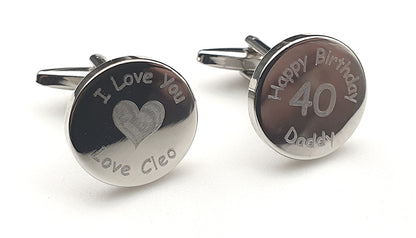Set of Two round cufflinks with engraved text around each keyring on a white background