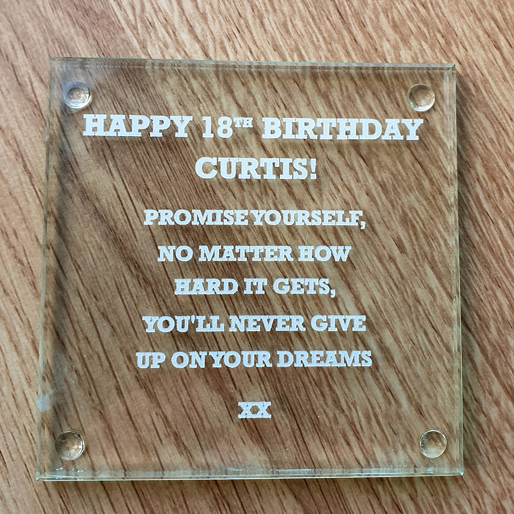 Square Glass coaster with birthday message on a wooden background surface 