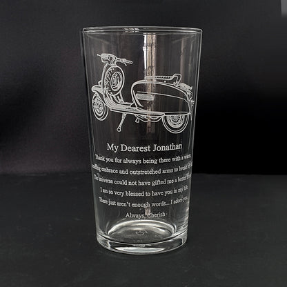 Lamb scooter artwork with a large amount of text engraved below on the front of a beer glass