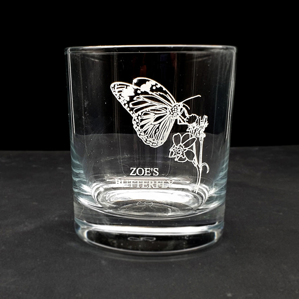 Clear glass tumbler with butterfly design and 'Zoe's Butterfly' text on a black background