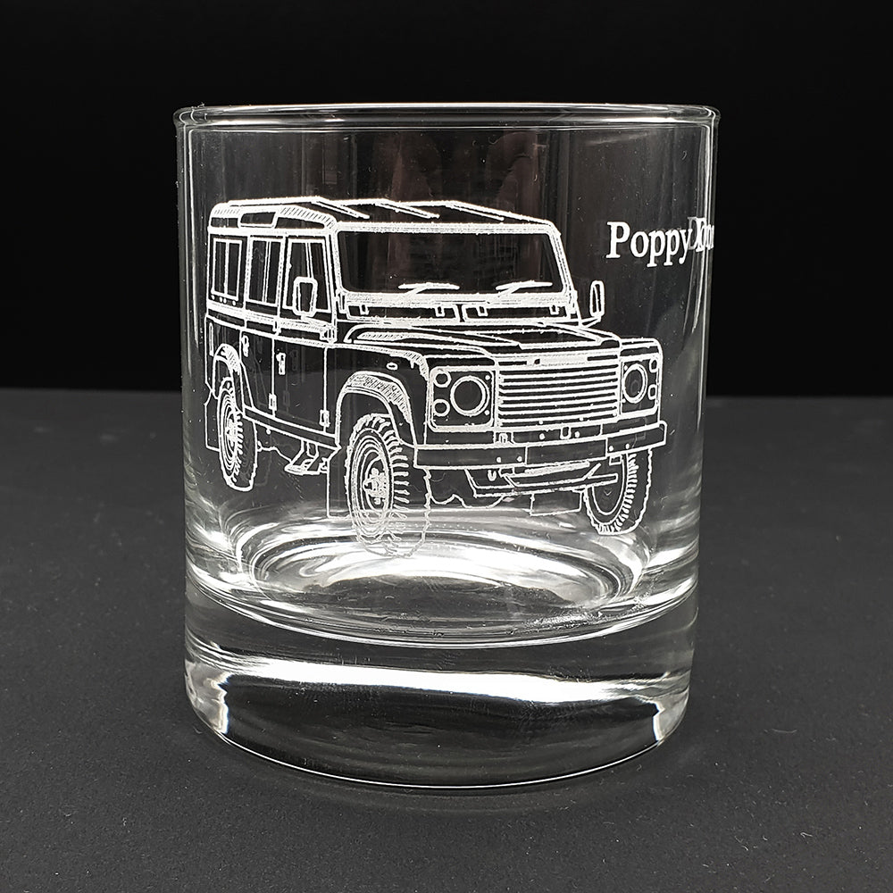 Clear glass tumbler with an engraved Land Rover design on a black background