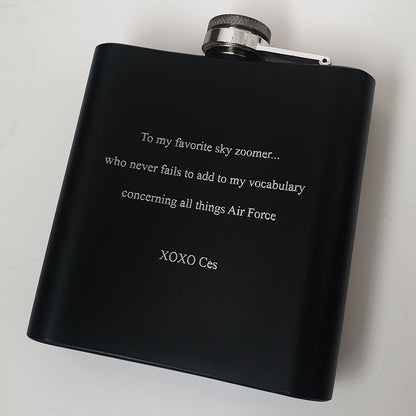 Black flask with engraved text on the back on a white background