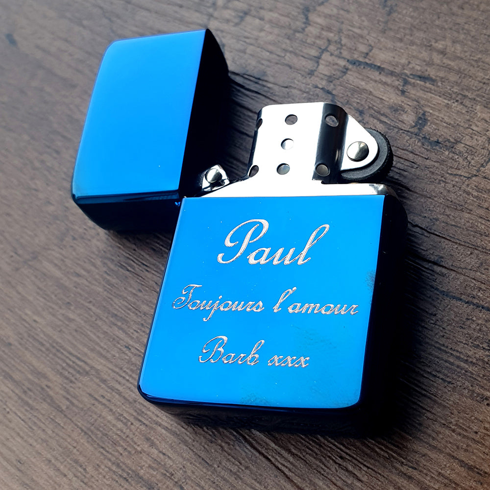 Blue lighter with engraved text in a script font on a wooden surface background