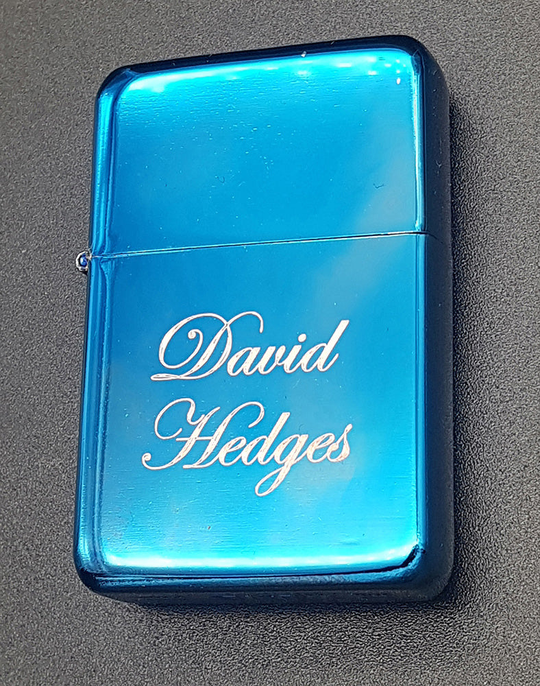 Blue lighter with 'David Hedges' engraved on a gray background