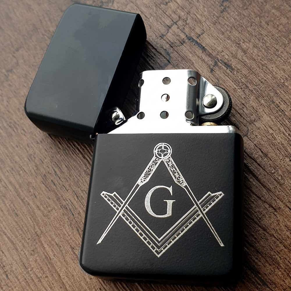 Black lighter with Masonic symbol on a wooden surface