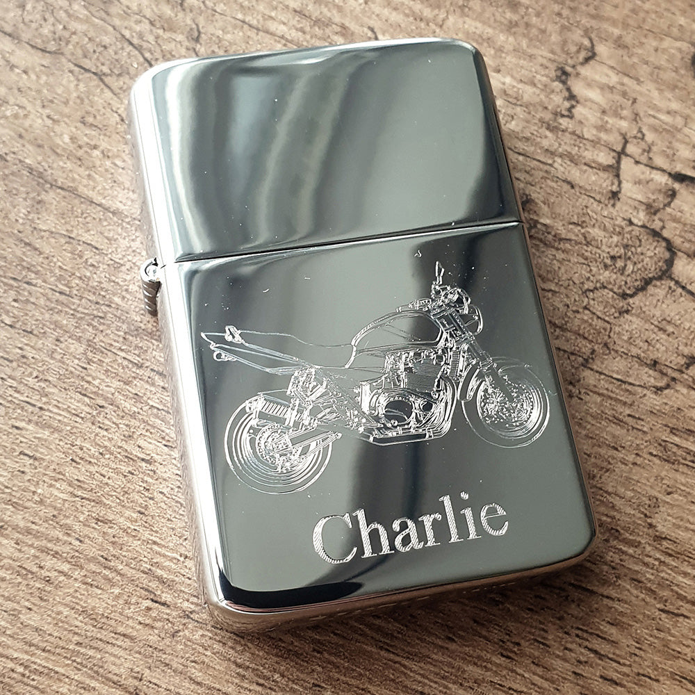 Chrome Silver lighter with GSX motorcycle design and 'Charlie' engraving on a wooden surface