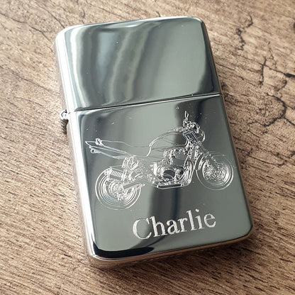 Chrome Silver lighter with GSX motorcycle design and 'Charlie' engraving on a wooden surface