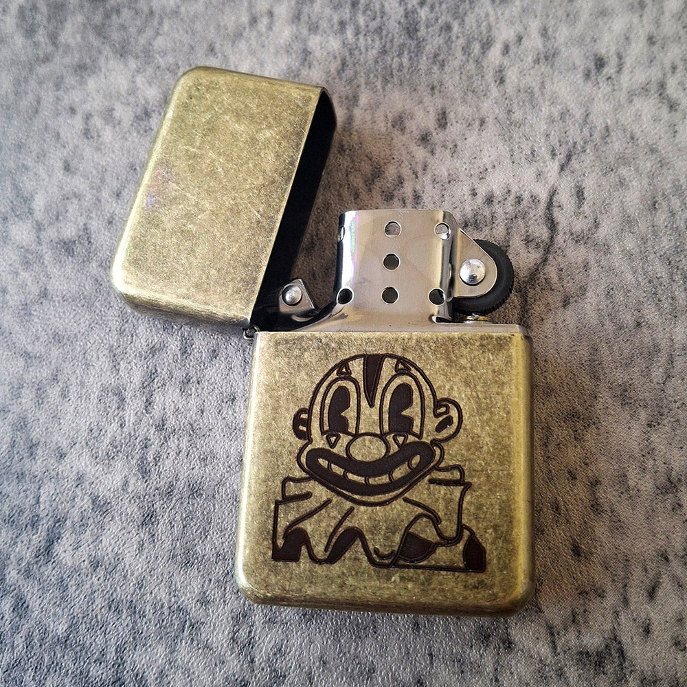 Vintage Brass Style Lighter engraved with a Crazy clown artwork.