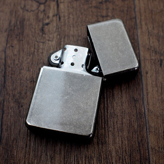 Open vintage style silver petrol lighter on wood background