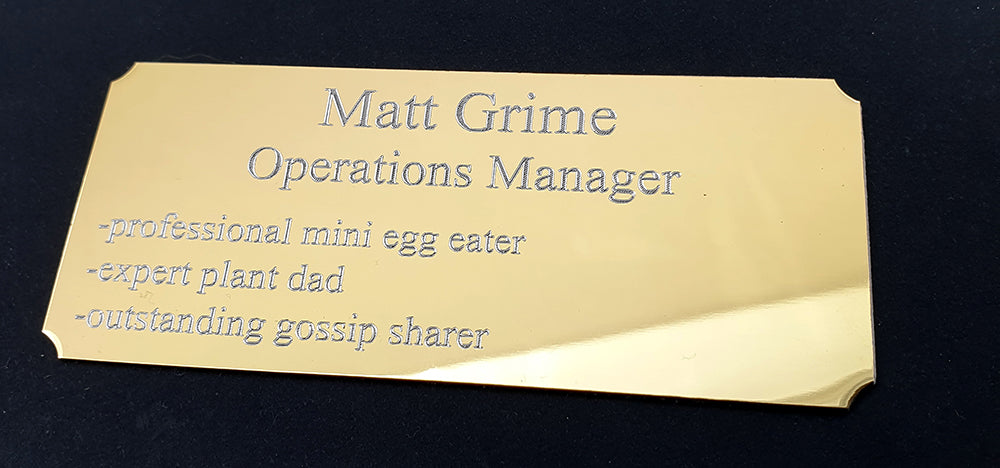 Gold cut corner plaque with Name and humorous job description on a black background