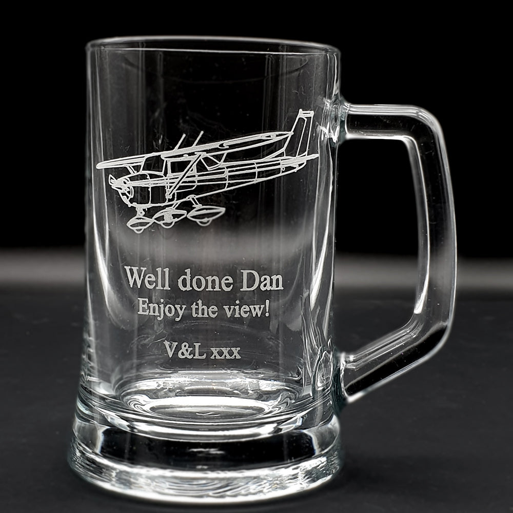 Clear glass mug with Cessna 152 airplane engraving and personalized text on a dark background