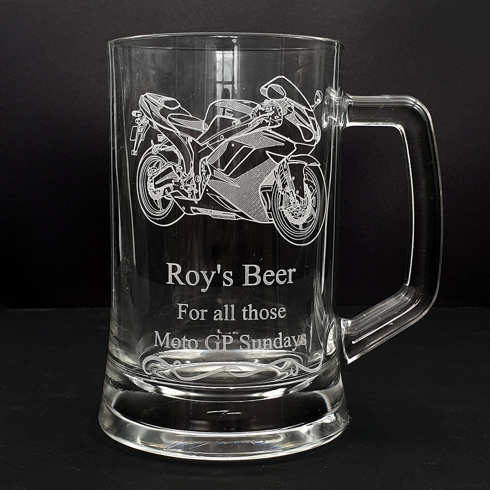Glass mug with track racing motorcycle engraving and text on a black background