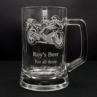 Glass mug with track racing motorcycle engraving and text on a black background
