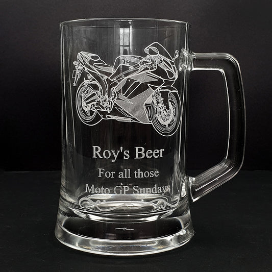 Glass mug with track racing motorcycle engraving and text on a black background