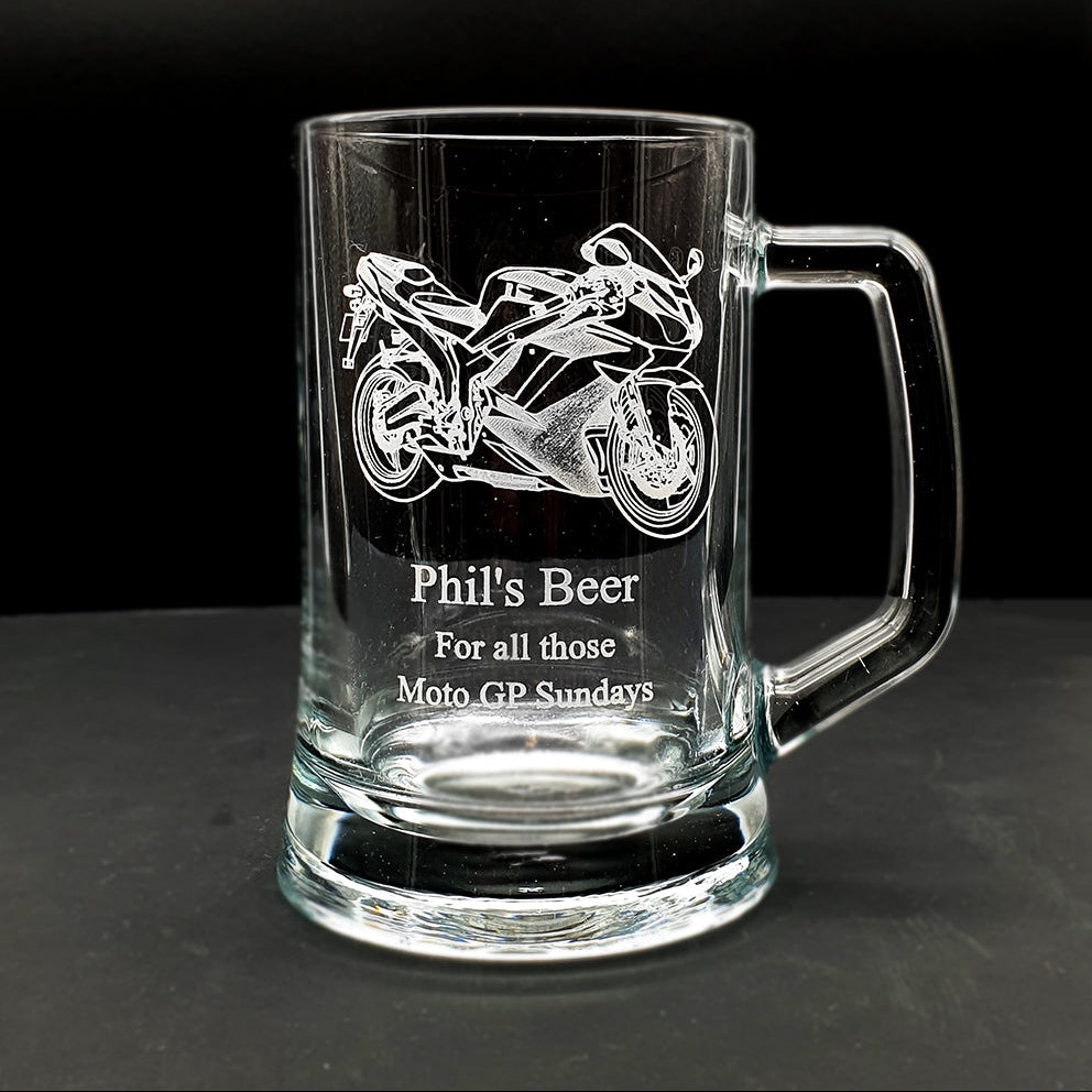 Clear glass mug with  motorcycle engraving and text on a black background