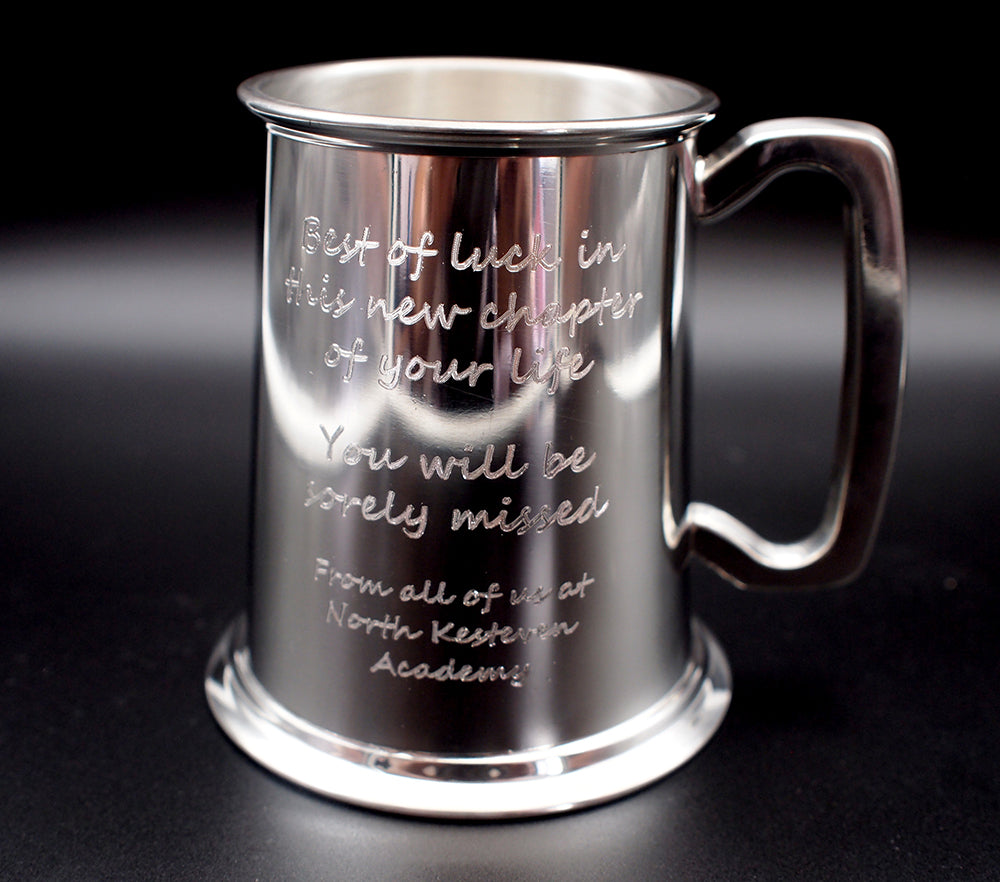 Pewter mug with engraved text on a black background