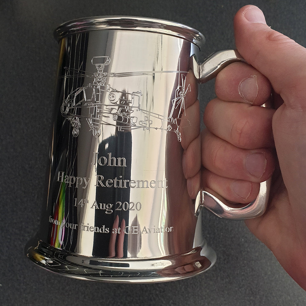 Silver tankard with our Apache engraved text and design, held by a hand against a dark background