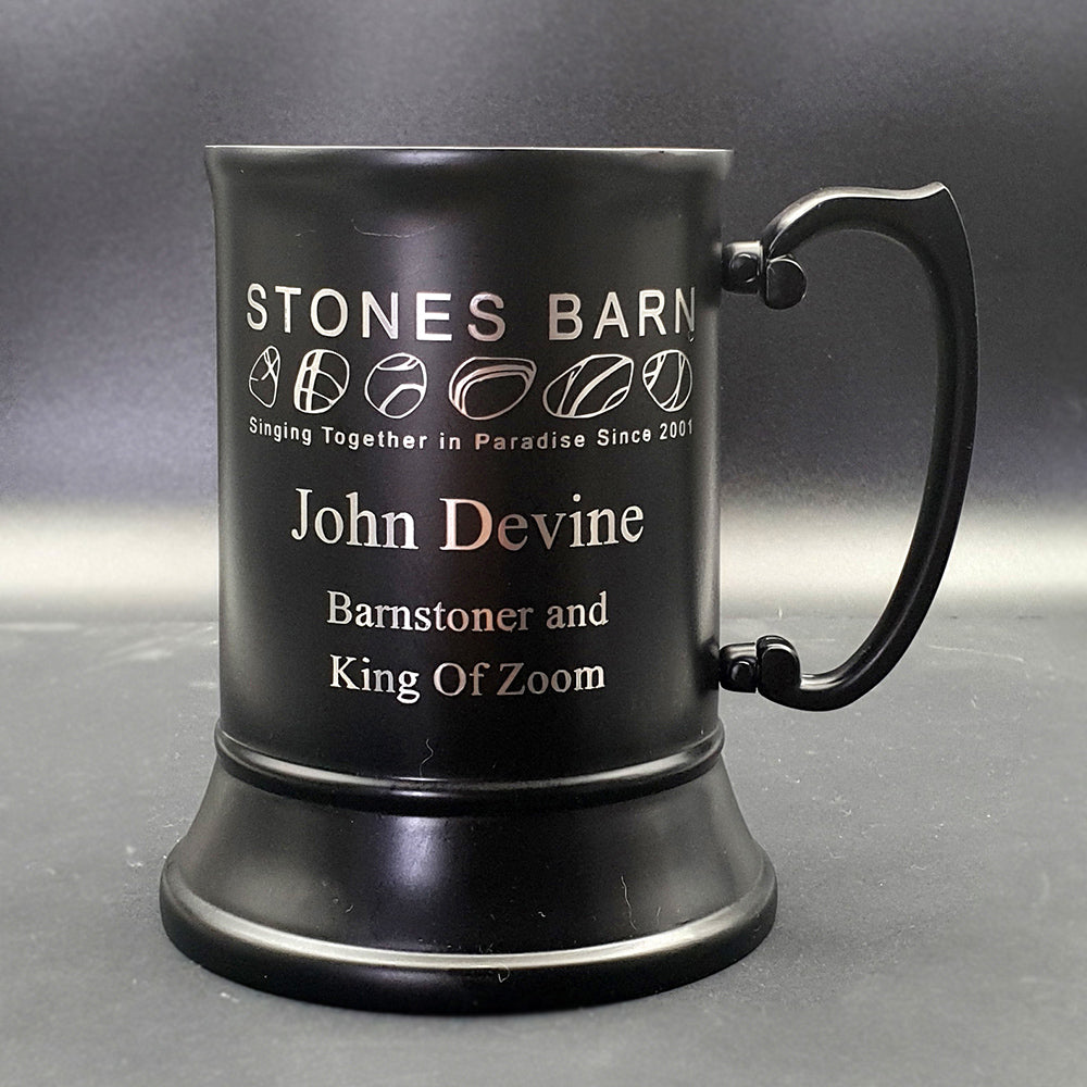 Black steel tankard with logo and text against grey background