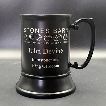 Black steel tankard with logo and text against grey background