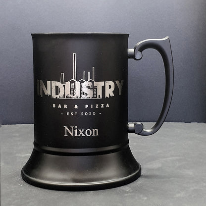 Black mug with 'Industry Bar & Pizza' and 'Nixon' branding on a gray background