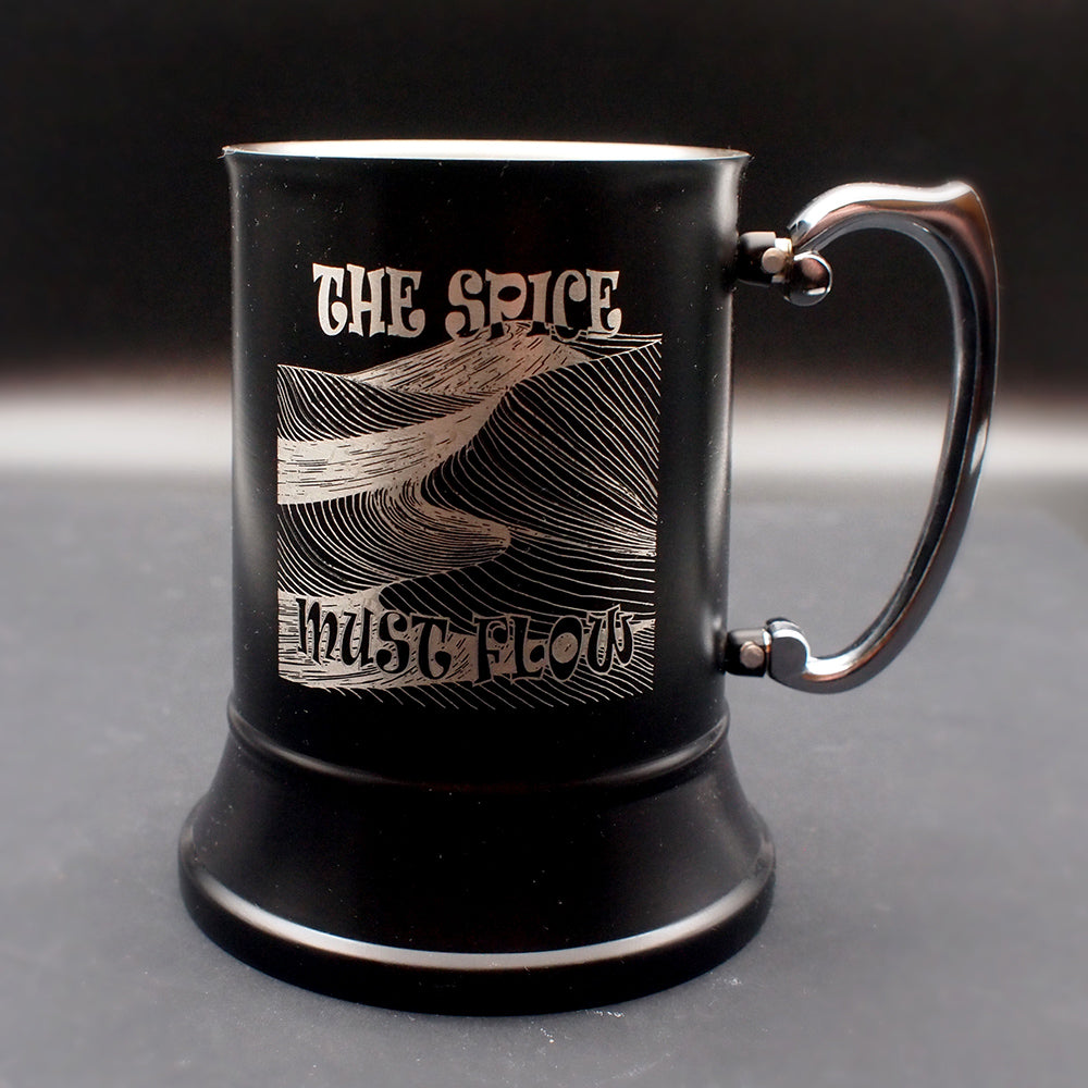 Black mug with engraved design and text on a dark background