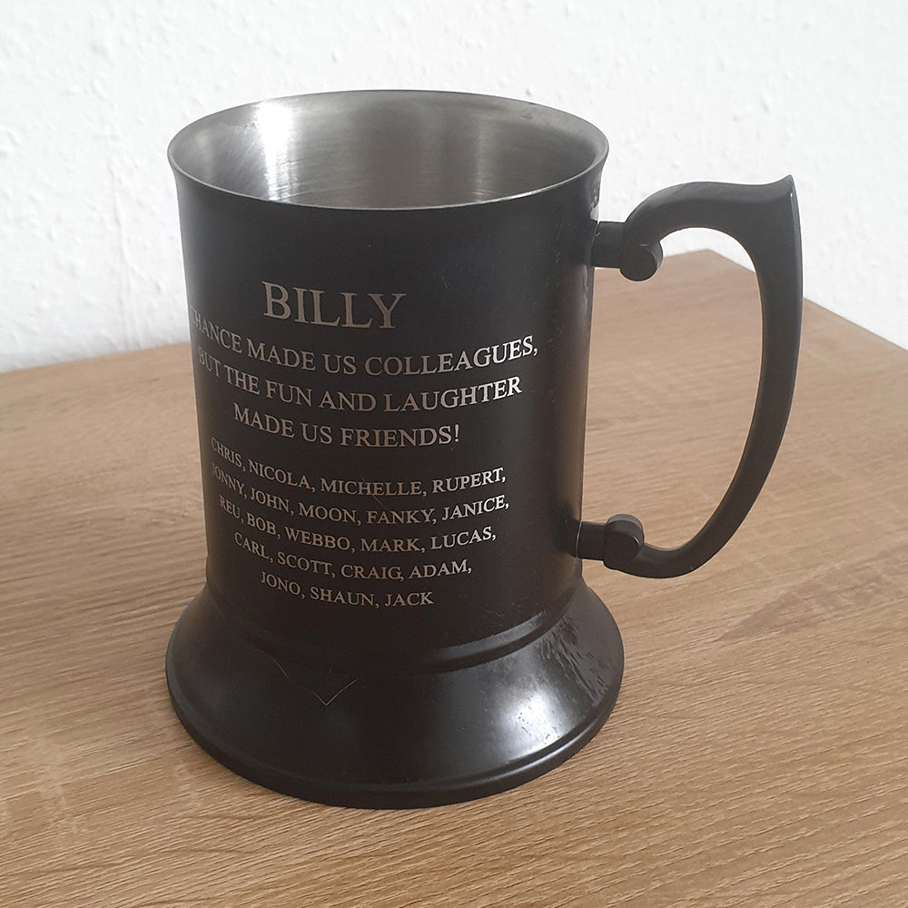 Black Steel mug with engraved text  and names on a wooden surface