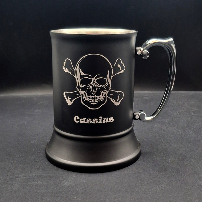 Black mug with skull and crossbones design and 'Cassius' Engraving on a dark background