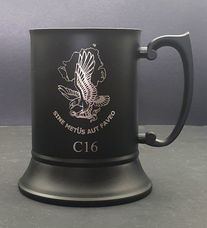 Black mug with engraved eagle design and text on a gray background