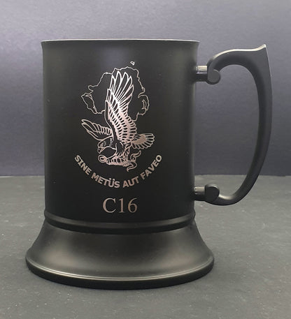 Black mug with engraved eagle design and text on a gray background