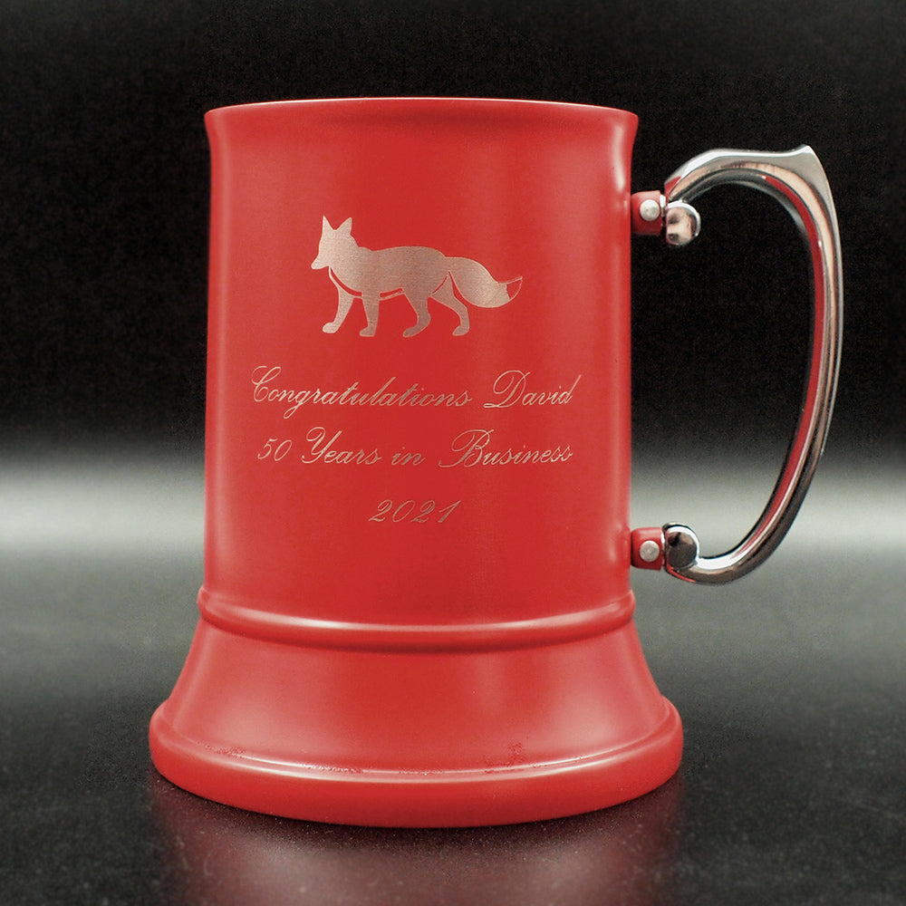 Red mug with engraved text and fox image with silver handle on a dark background