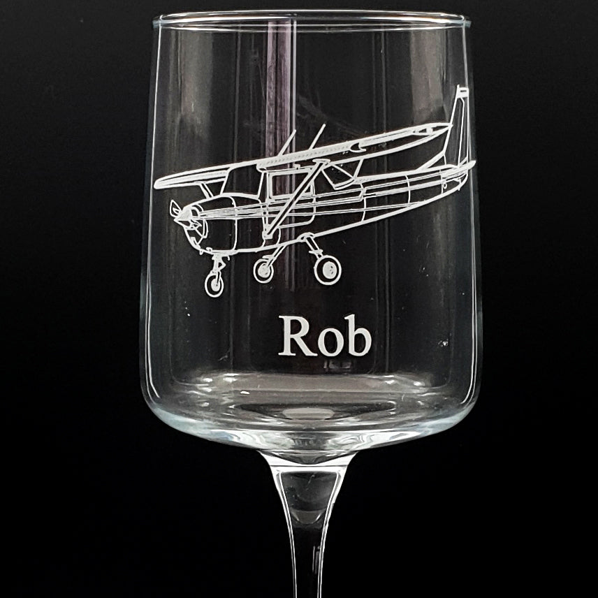 wine glass with Cessna 152 airplane engraving and name 'Rob' on a black background