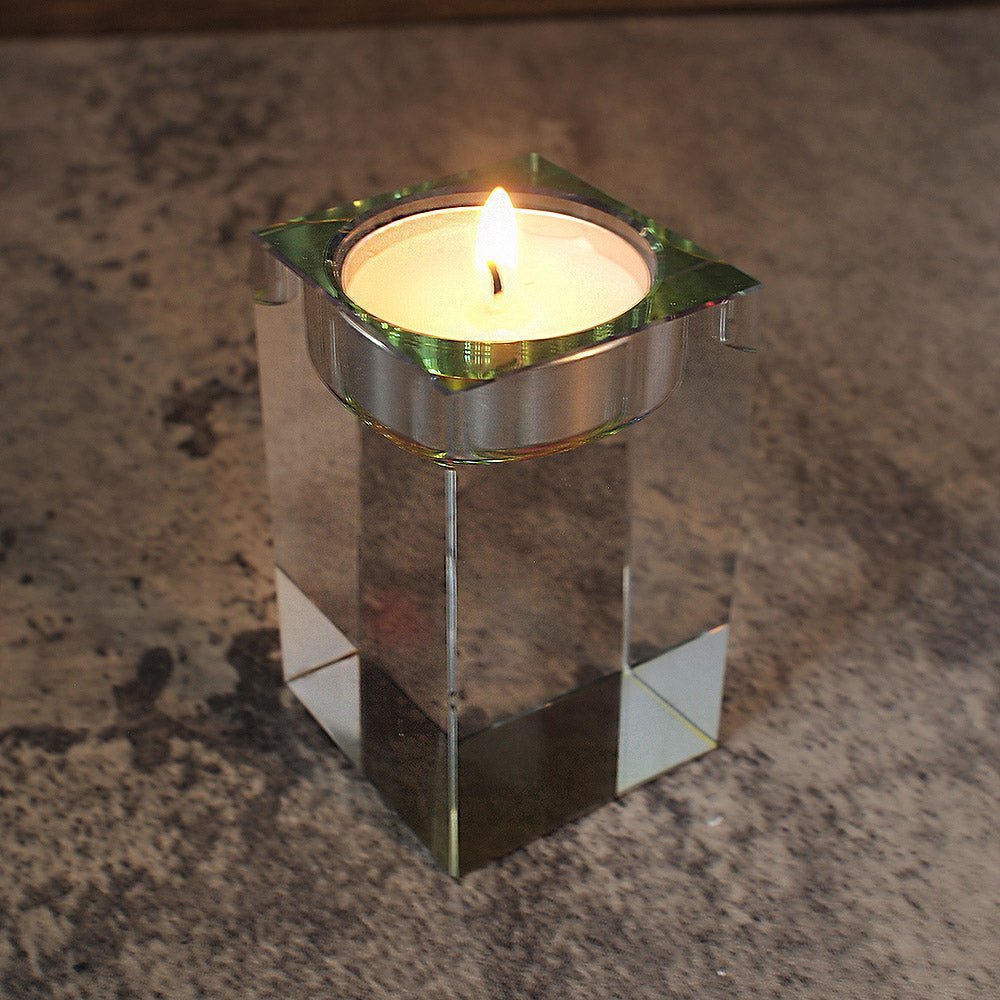 high angle image of optic glass tealight holder with lit candle