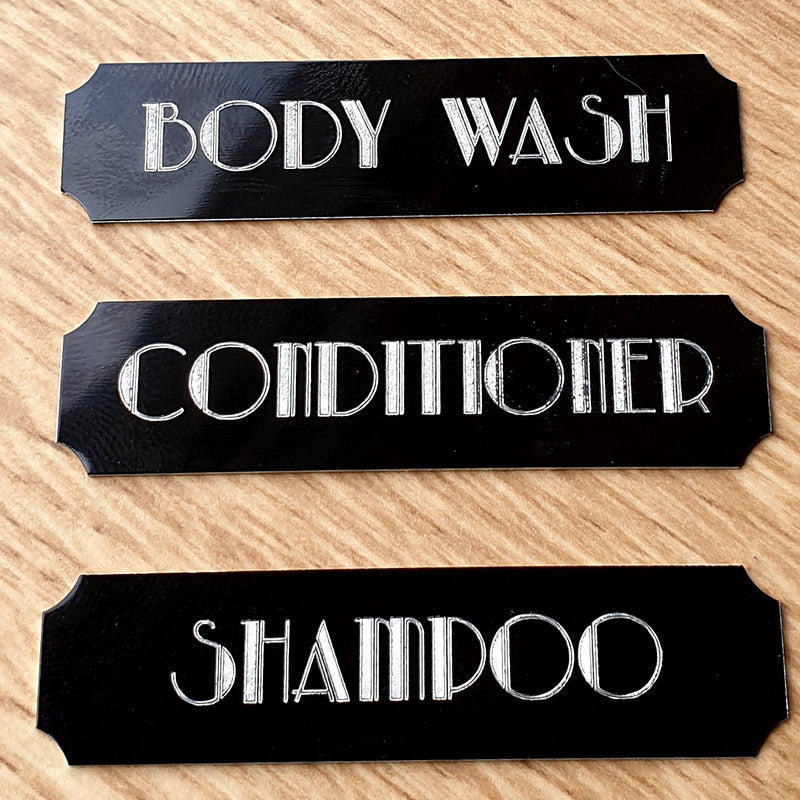set of three engraved plaques with cut corners and the text Body wash, conditioner and Shampoo