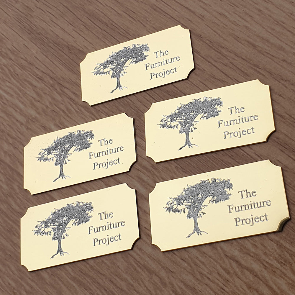 Set of Five gold plaques labels with tree design and 'The Furniture Project' text on a wooden surface background