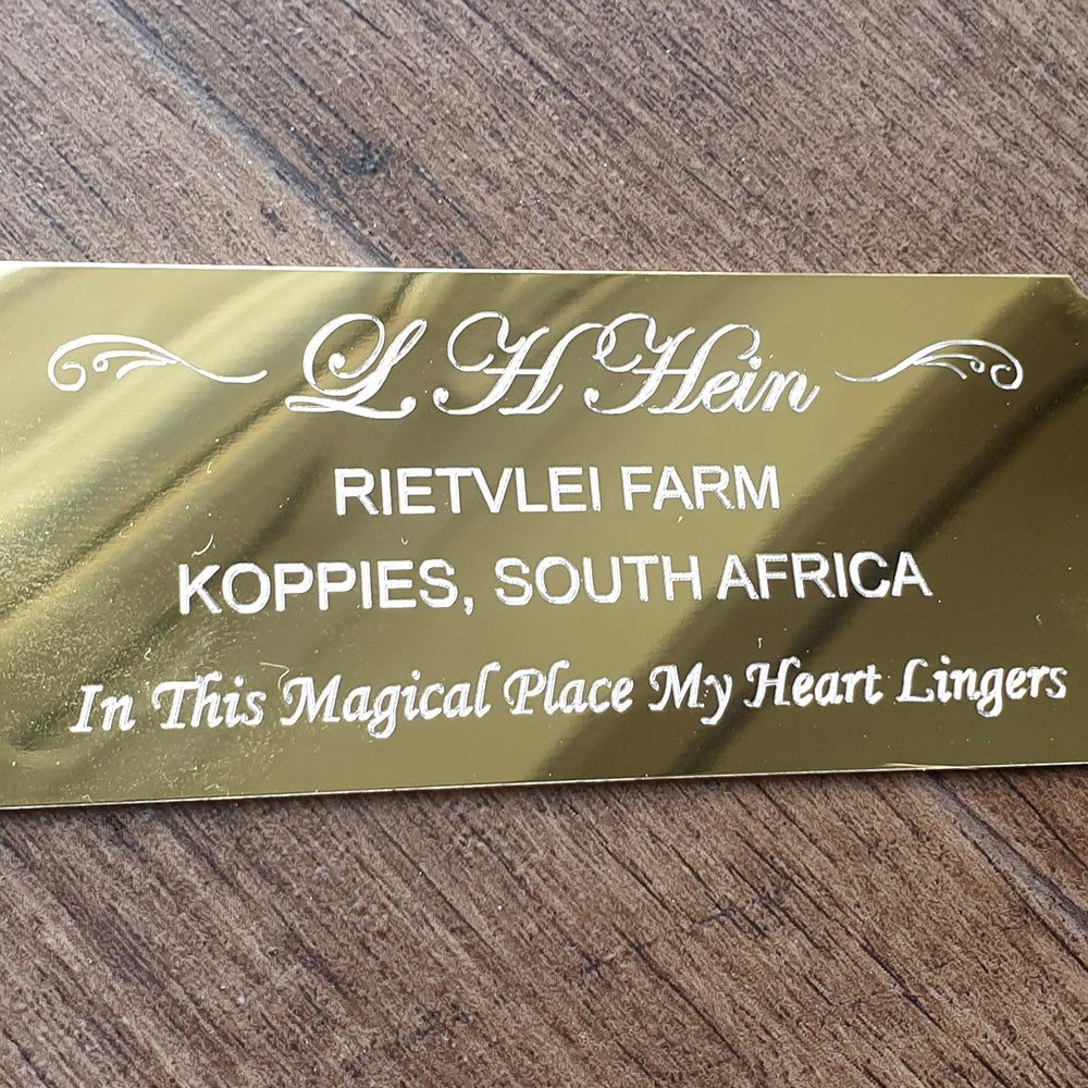 Gold nameplate with text on a wooden surface