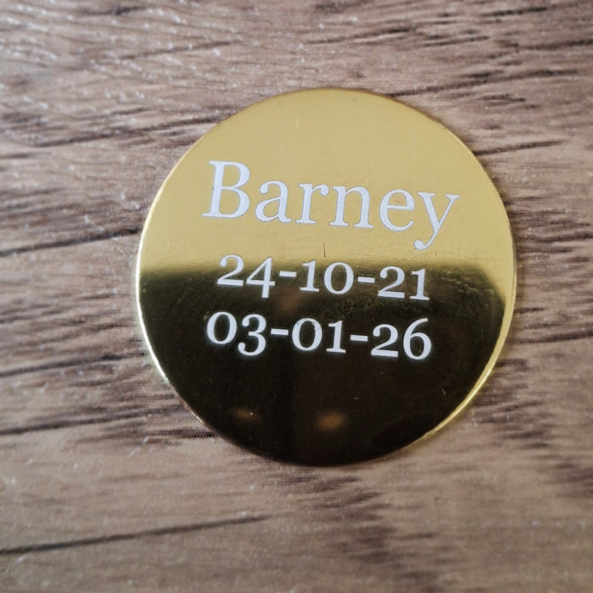 Small round plaque engraved with Barney and two dates