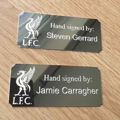 Two Silver plaques with the Liverpool FC logo and names Steven Gerrard and Jamie Carragher.