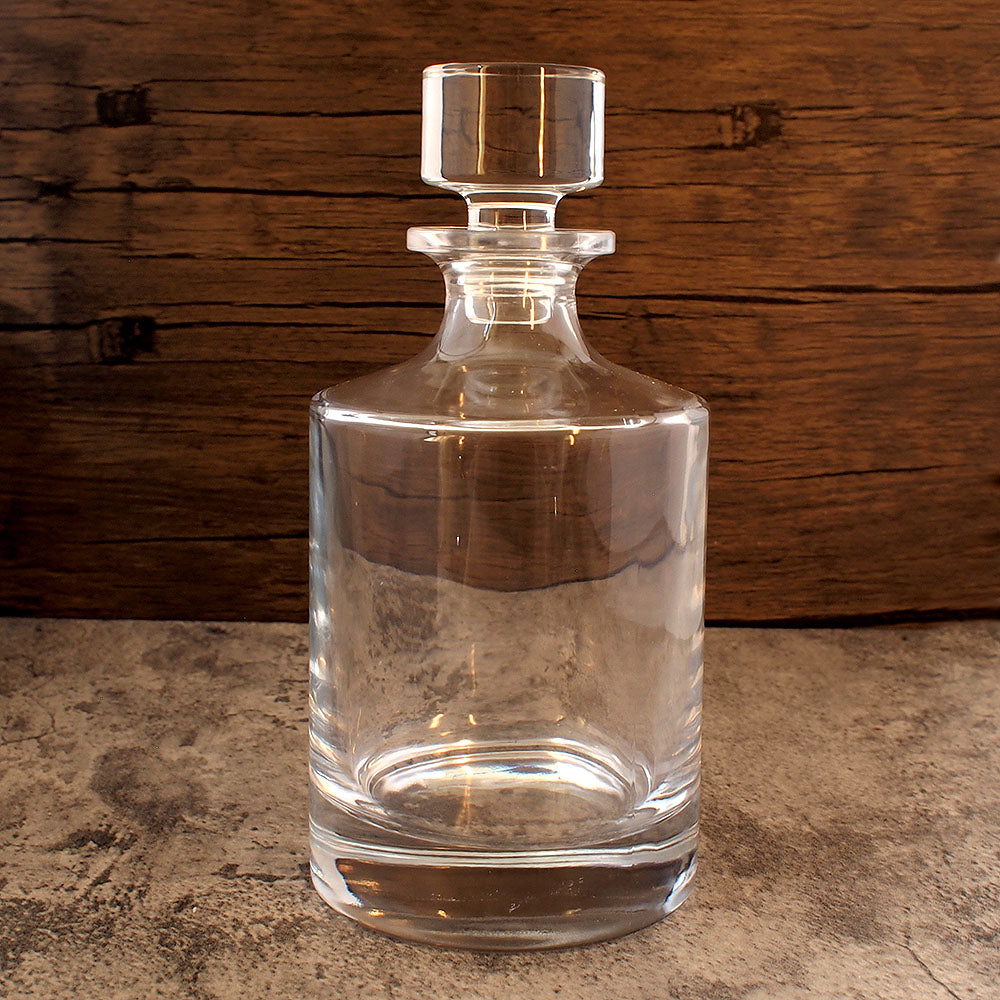 front image of round glass spirits decanter  with stopper in place. 